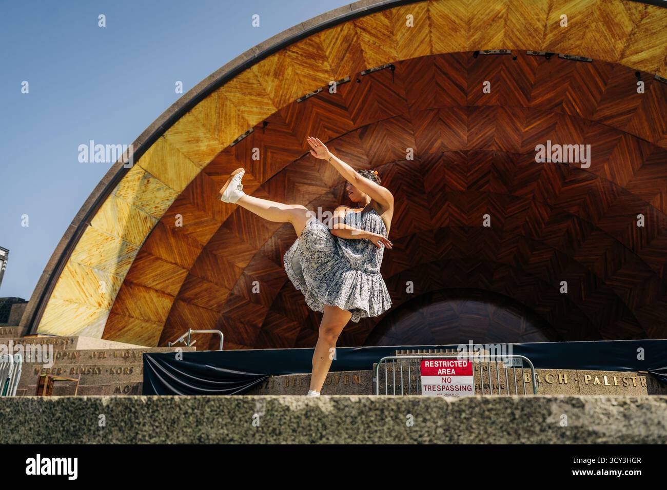 Energiegeladene Frau, die modernen Tanz auf der Bandshell-Bühne im Freien aufführt Stockfoto