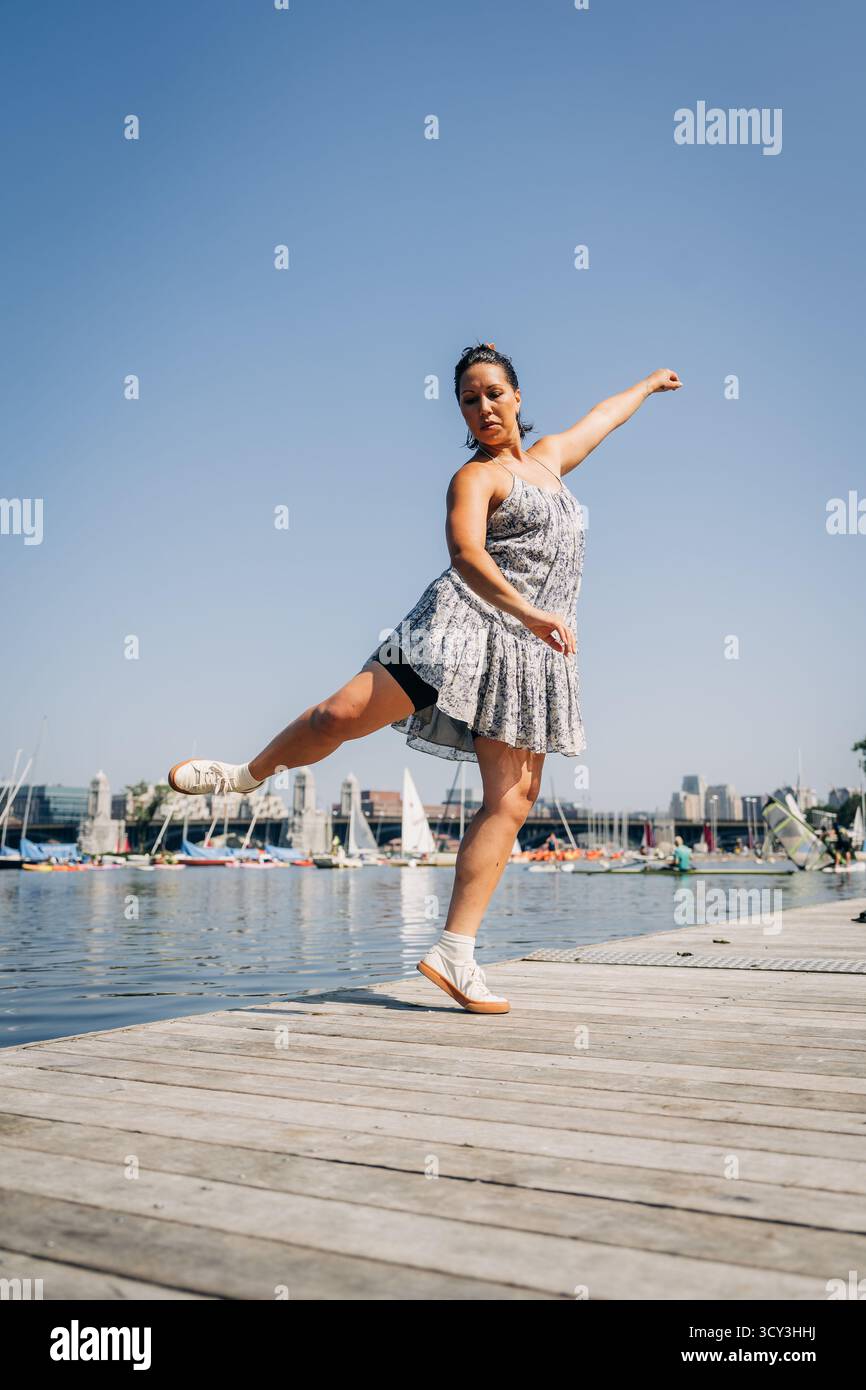 Frau, die Bewegung ausdrückt, tanzt auf dem Dock der Stadt Stockfoto