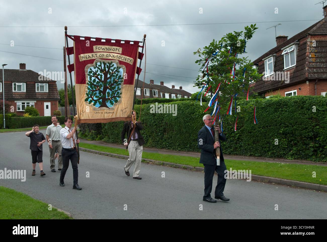 Fownhope Heart of Oak Society Club Walk Day. Der dekorierte Eichenblock, gefolgt von dem Vereinsbanner, wird zum New Inn getragen, um die Club Walk Day Parade im Dorf zu beginnen. Fownhope, Herefordshire, England, 2018 2010. Juni 1987, Großbritannien HOMER SYKES Stockfoto