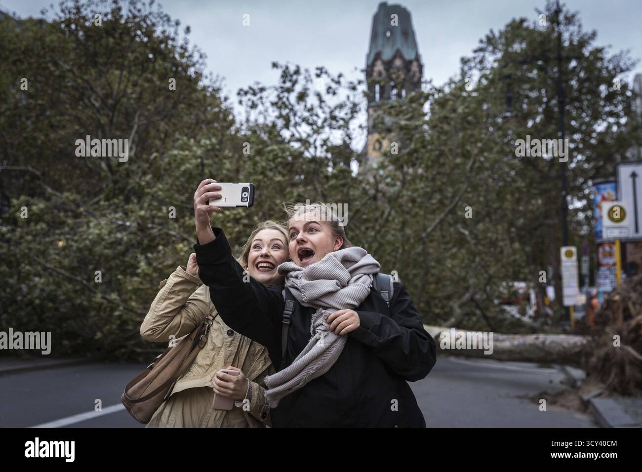 DEU Deutschland Berlin Feuerwehreinsatz am Kurfürstendamm. Sturm Xavier hatte Bäume auf die Straße fallen lassen. Zwei Frauen machen ein Selfie Stockfoto