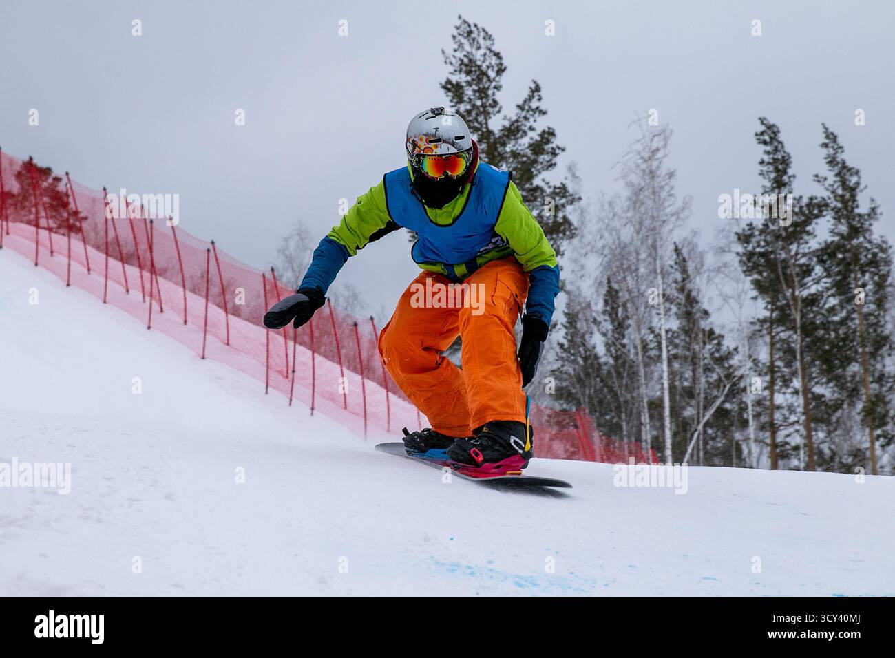 Snowboarder in bunten Kleidern auf dem Rennsport Snowboard Cross Stockfoto