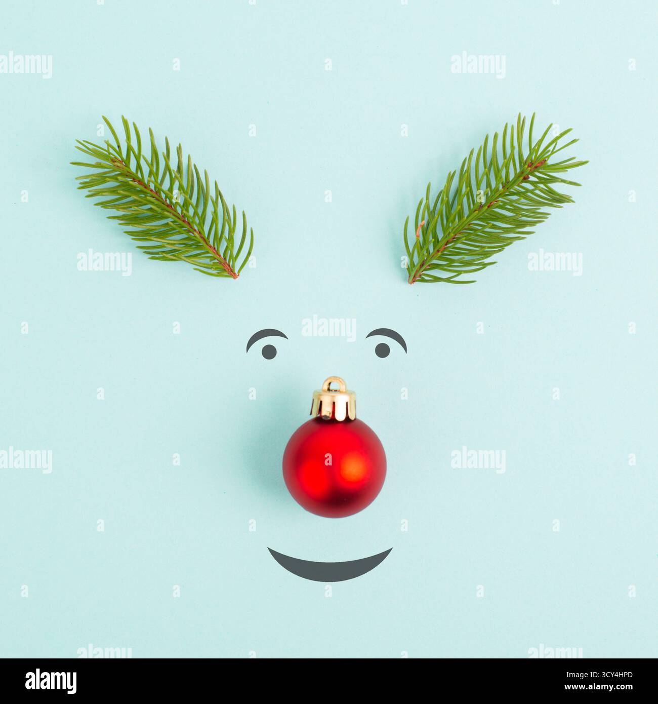 Gesicht Eines Rentiers mit roter Kugelnase, Tannengeweih und freundlichen Augen, Grußkarte „Frohe Weihnachten“ Stockfoto