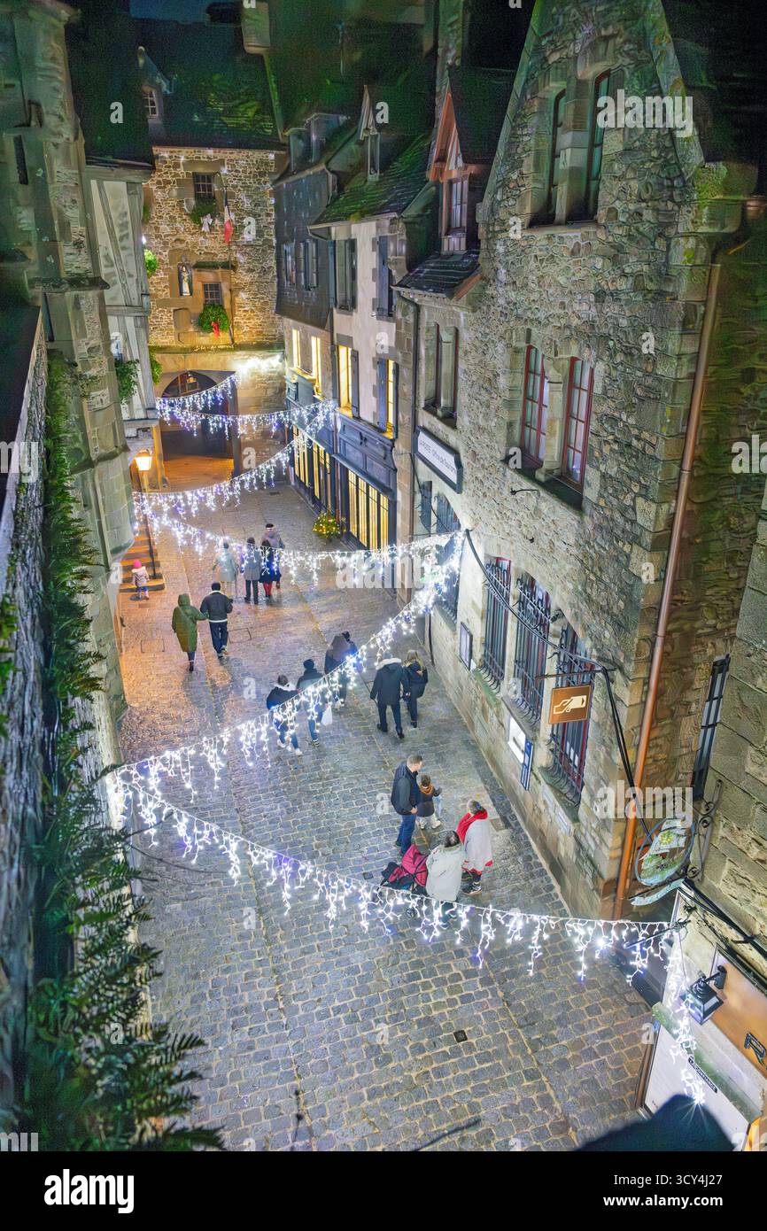 MONT SAINT-MICHEL, FRANKREICH – 15. DEZEMBER 2024: Touristen schlendern entlang einer charmanten, beleuchteten Kopfsteinpflasterstraße im historischen Mont Saint-Michel in n Stockfoto