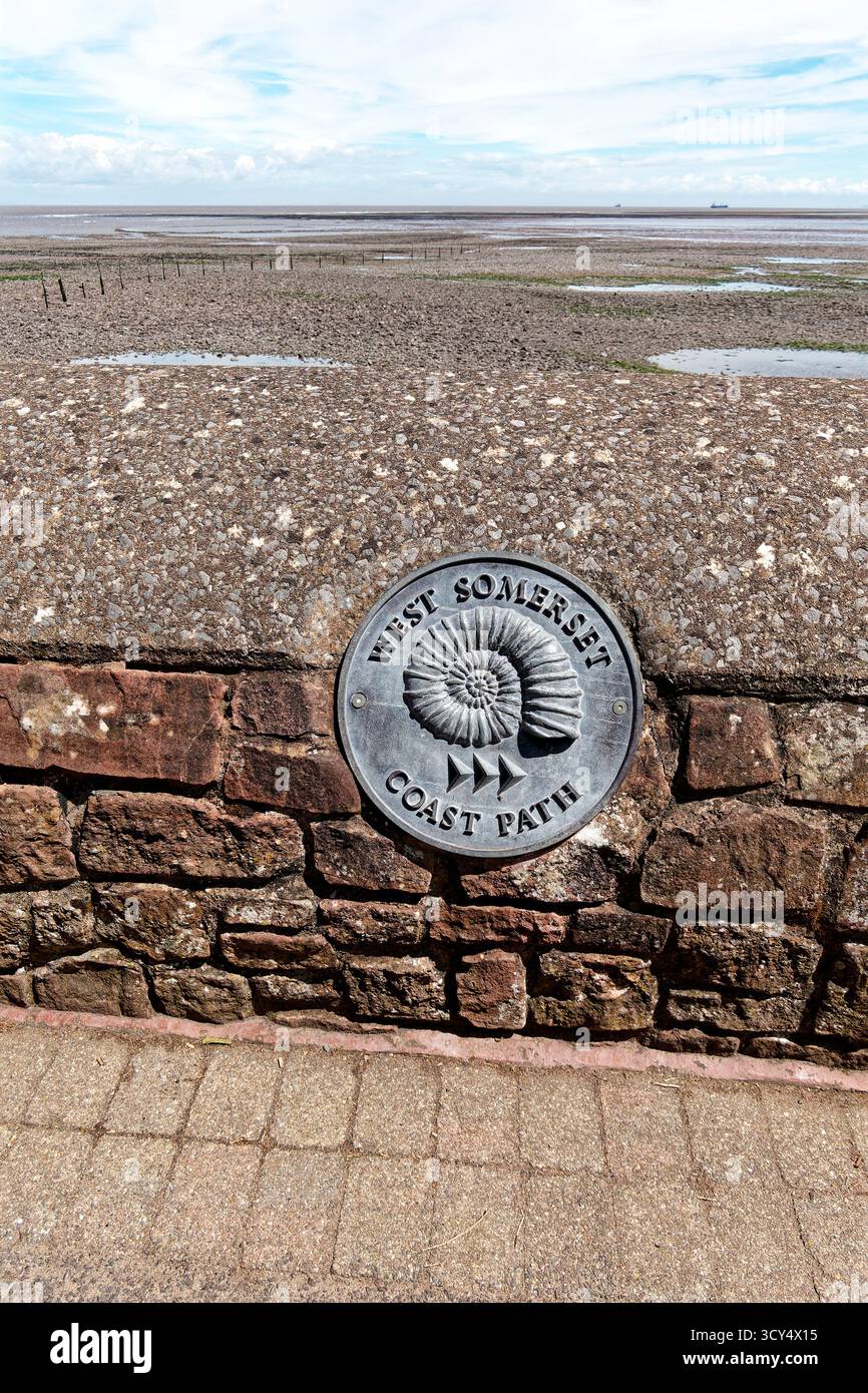 Minehead, Somerset, England, Vereinigtes Königreich - 28. Mai 2025: Ein Schild am West Somerset Coast Path, das in einer Mauer angebracht ist, die einen Ammoniit darstellt, und sich in der Nähe des Hafens von Minehead befindet Stockfoto