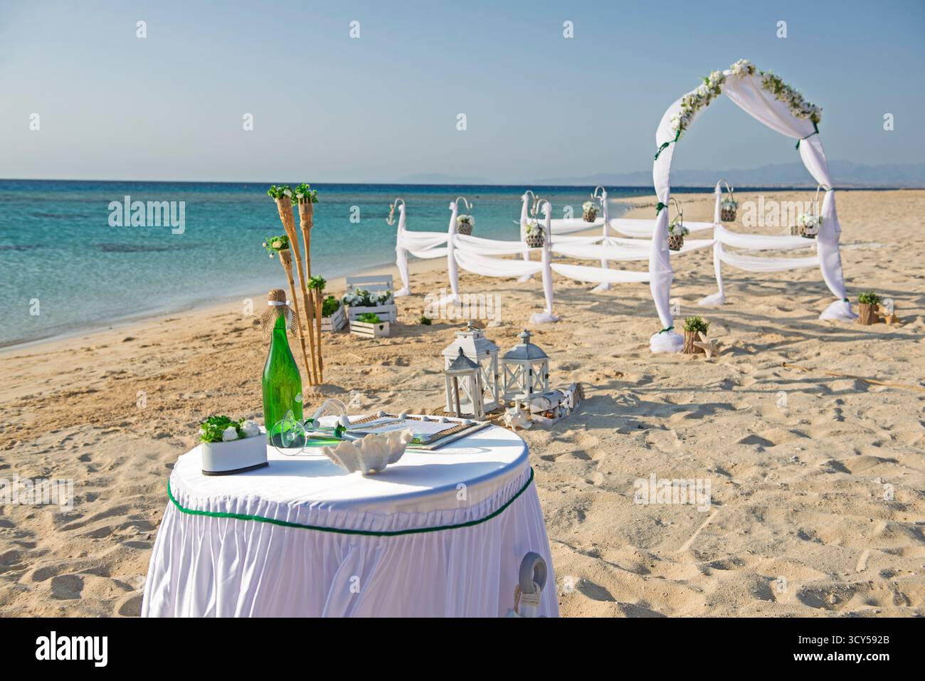 Setup von Hochzeit ehe Gang mit Vorhängen und Bogen auf Sandy Tropical Beach Paradise Ocean Hintergrund zu öffnen. Stockfoto