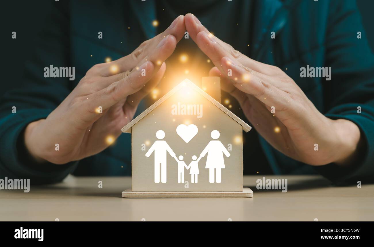 Versicherung Haus und Familie Gesundheit leben Konzept. Eine Hand, die ein Modell eines Hauses mit einigen Holzblöcken bedeckt. Sachversicherung, Hausschutz Stockfoto