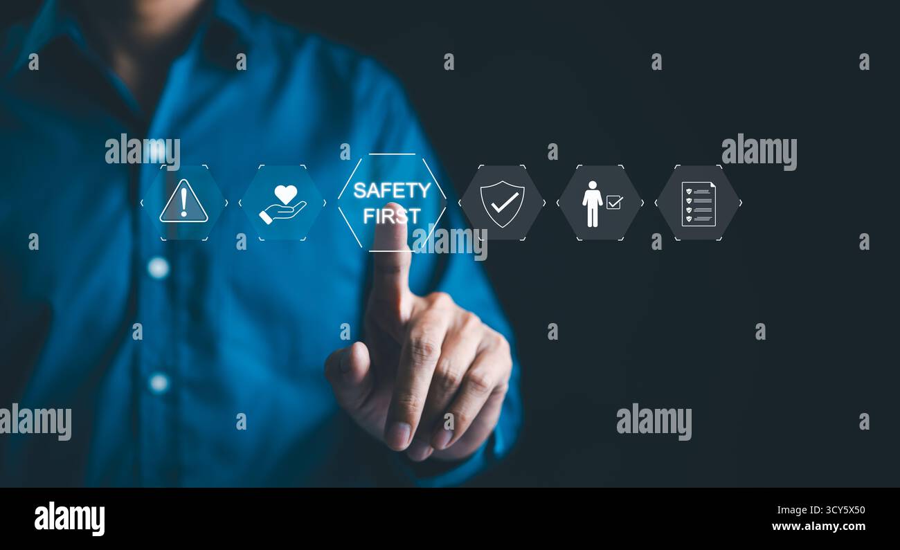 Safety First-Konzept. Arbeitssicherheit, Ein Geschäftsmann mit Sicherheitssymbolen, die das Konzept „Sicherheit an erster Stelle“ betonen, mit Symbolen für Warnungen, Stockfoto