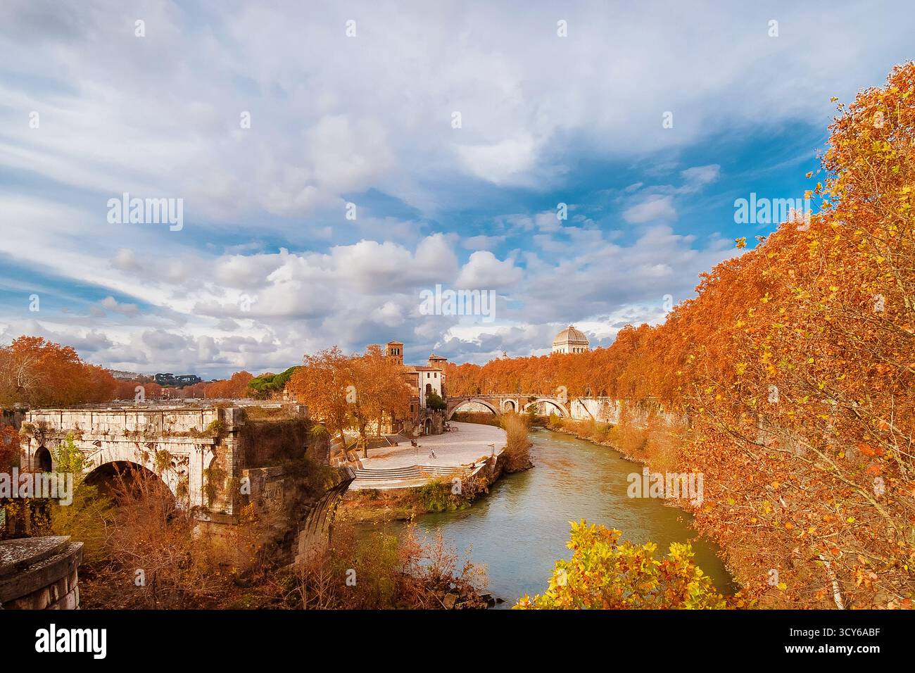 Herbst und Laub in Rom. Orangene und gelbe Platanen in der Nähe der Tiberinsel mit einer alten römischen Brücke im historischen Zentrum der Stadt Stockfoto Herbst und Laub in Rom. Orangene und gelbe Platanen in der Nähe der Tiberinsel mit einer alten römischen Brücke im historischen Zentrum der Stadt Stockfoto