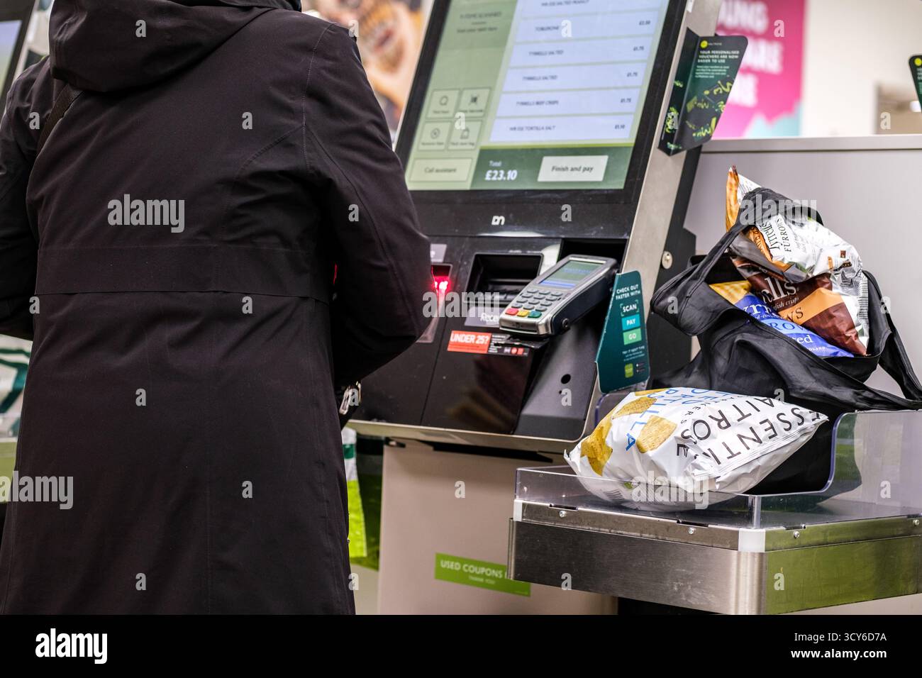 Epsom, London, Großbritannien, 17. Oktober 2025, Kunden, die Lebensmittel bei Automated Payment Tills bezahlen Stockfoto