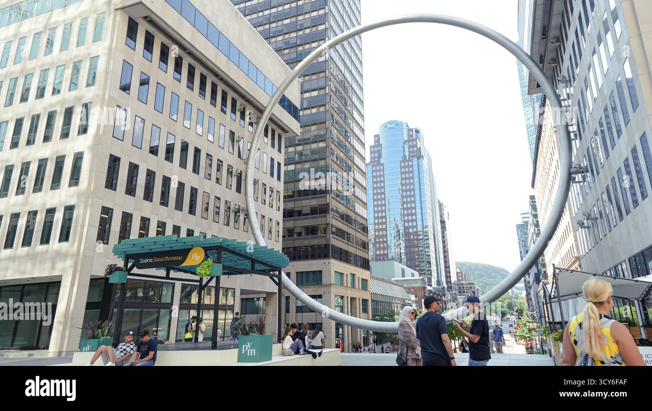 Montreal QC, Kanada - 20. Juli 2025: Die Ringskulptur am Place Ville Marie in Montreal, umrahmt von zeitgenössischen Gebäuden und lebhaften urbanen Aktivitäten Stockfoto