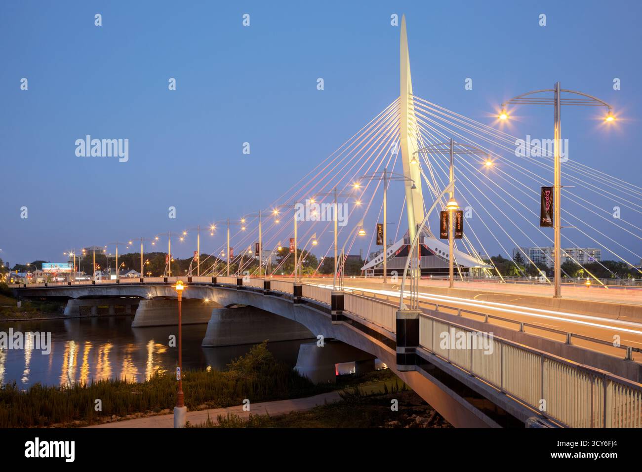 Die Fußgängerbrücke Esplanade Riel überquert den Red River in der Abenddämmerung in der Innenstadt von Winnipeg, Manitoba, Kanada Stockfoto