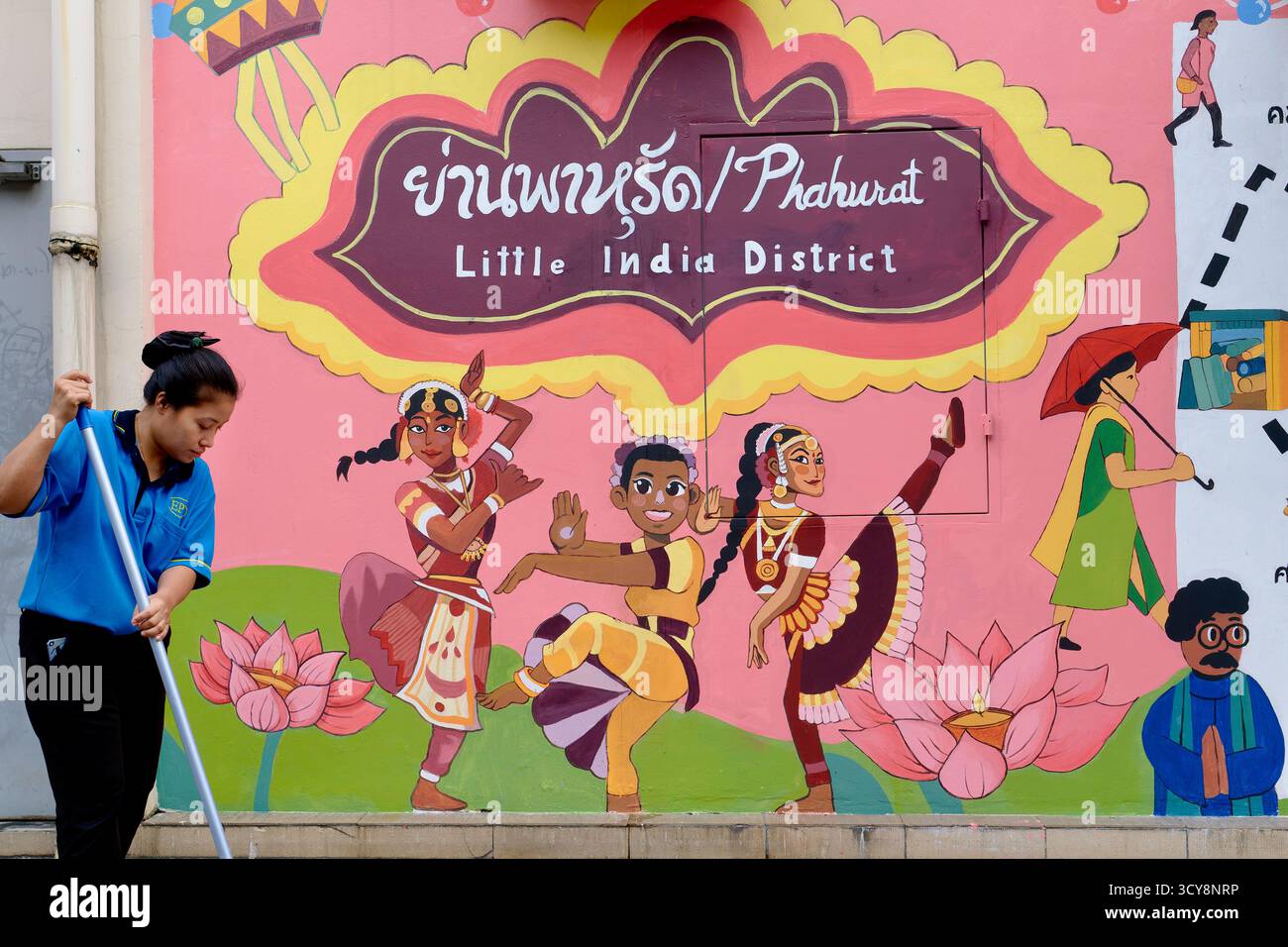 Ein lebhaftes Wandgemälde im indischen Viertel Phahurat (Pahurat) in Bangkok, Thailand, mit indischen Tänzern; mit einer Straßenreinigung vorne Stockfoto