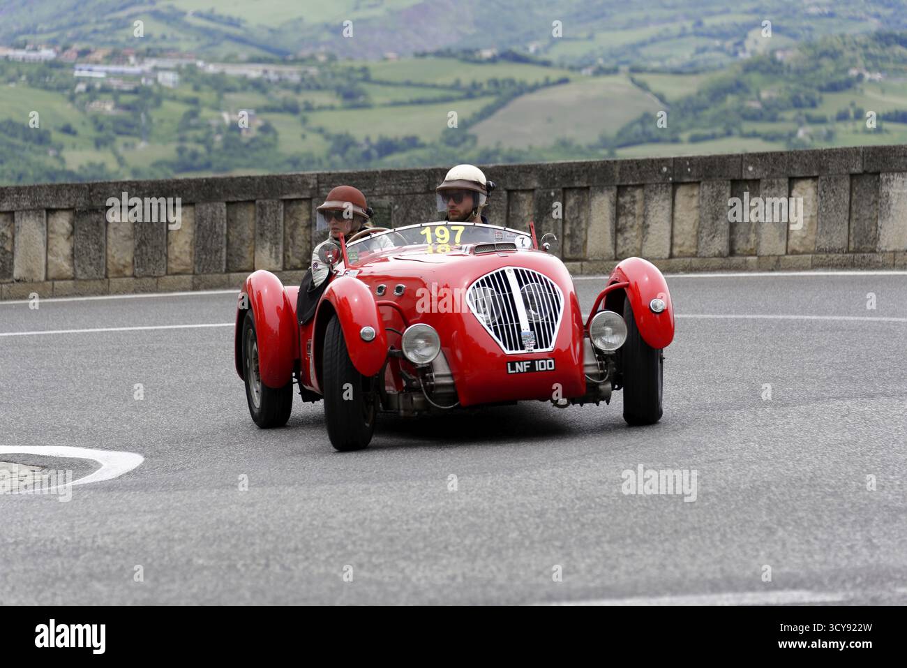 Nr. 197, Healey 2400 Silverstone, Baujahr 1950, rotes Auto mit zwei Insassen in klassischen Helmen auf einer kurvenreichen Straße, Mille Miglia 2014 oder 1000 Miglia, cla Stockfoto