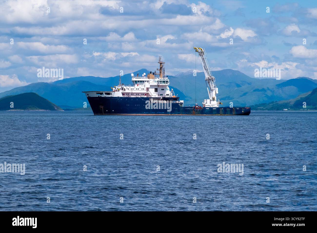 Northern Lighthouse Board Schiff Pharos vor Anker in ruhigen Küstengewässern mit weit entfernten Bergen Stockfoto