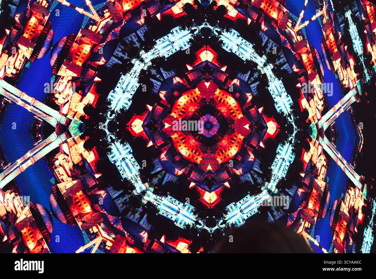 Kaleidoskop-Muster in Form einer abstrakten Stadt in Rottönen. Stockfoto