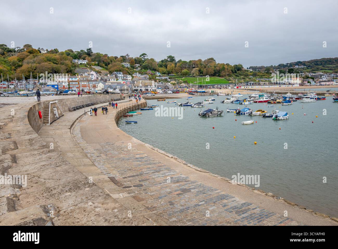 Cobb Harbour und Marina in der Küsten- und Küstenstadt Lyme Regis an der Küste von Dorset mit großer Hafenmauer und kleinen Booten. Stockfoto