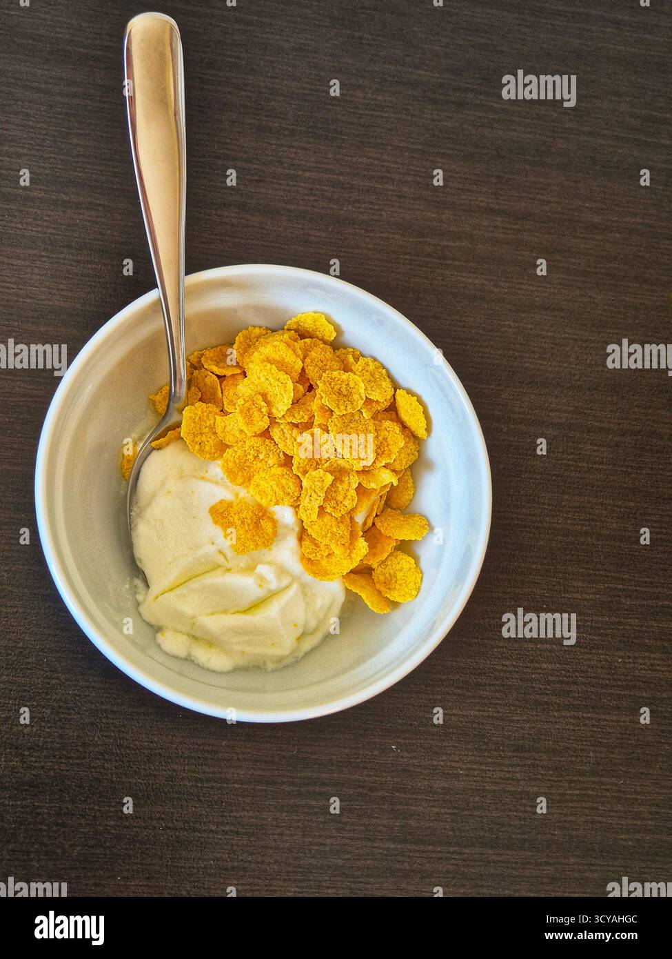 Joghurt mit Müsli in einer Schüssel. Ein leckeres Frühstück aus der Nähe - Smartphone-aufgenommenes Stockfoto