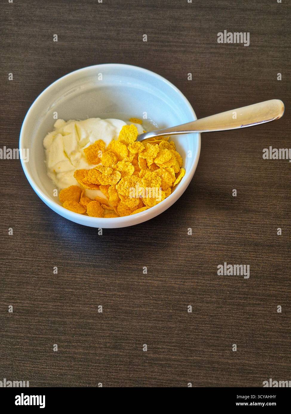 Joghurt mit Müsli in einer Schüssel. Ein leckeres Frühstück aus der Nähe - Smartphone-aufgenommenes Stockfoto