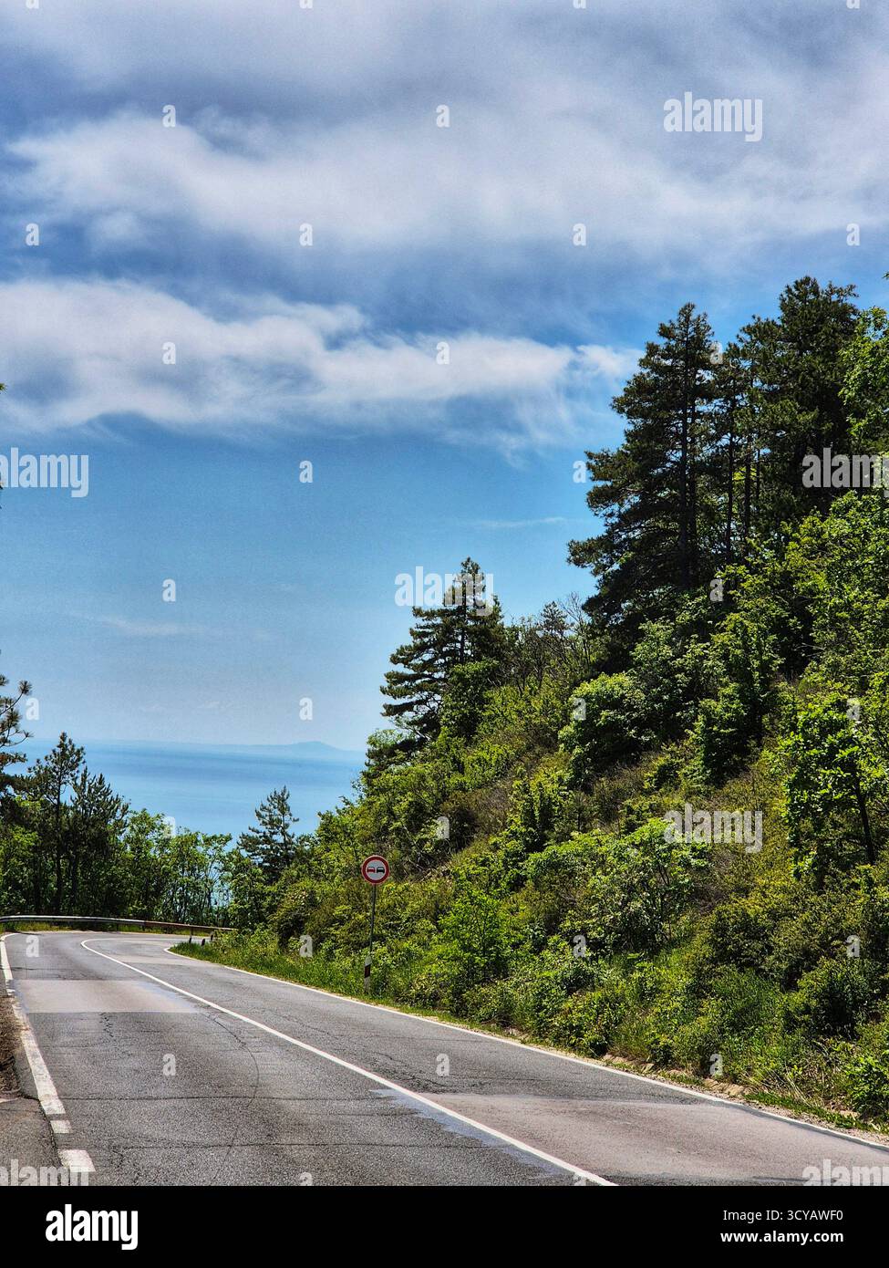 autobahnstraße in den Bergen. Meer im Hintergrund - Smartphone-aufgenommenes Stockfoto