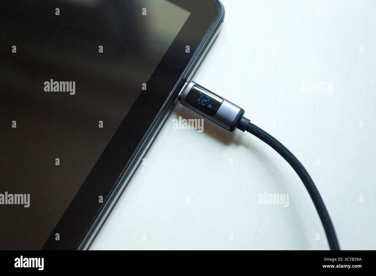Ansicht des Kabels mit dem Digitaldisplay, das an das schwarze Tablet angeschlossen ist Stockfoto