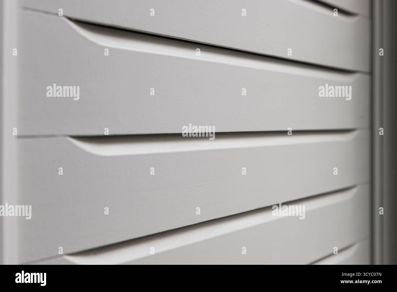 Nahaufnahme der Leisten einer weißen Holztür von einer Seite aus gesehen. Stockfoto