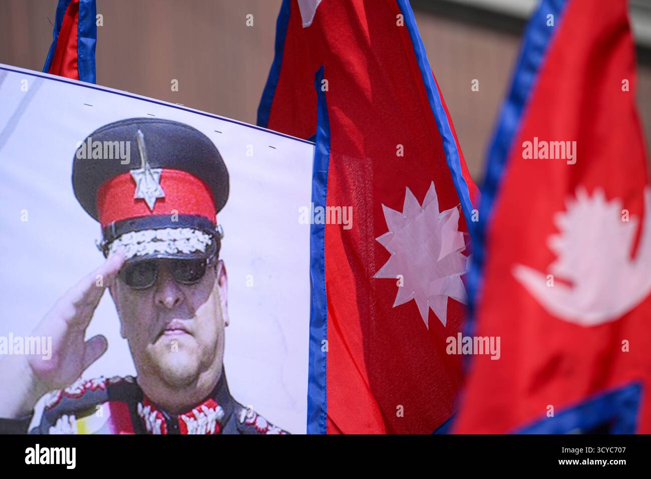Kathmandu, Nepal. 18. Oktober 2025. Ein Foto des ehemaligen Königs Gyanendra ist neben der Nationalflagge während eines Treffens royalistischer Anhänger in Samakhusi, Kathmandu, Nepal, am Samstag, den 18. Oktober, zu sehen. 2025 Foto: Safal Prakash Shrestha Credit: Safal Prakash Shrestha/Alamy Live News Stockfoto