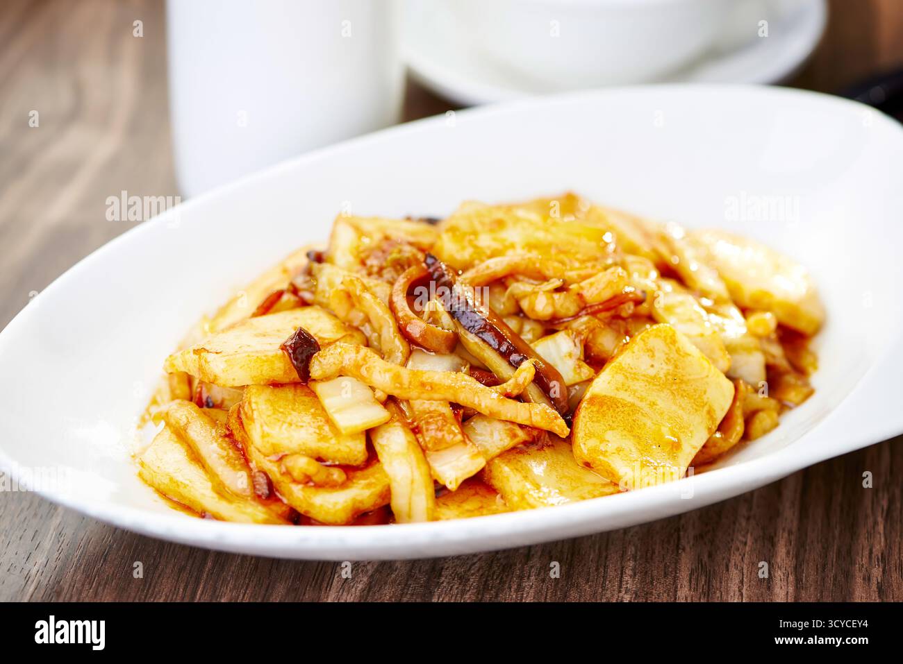 Gebratene Reiskuchen mit XO-Sauce serviert auf dem Teller mit seitlicher Aussicht auf asiatische Köstlichkeiten Stockfoto