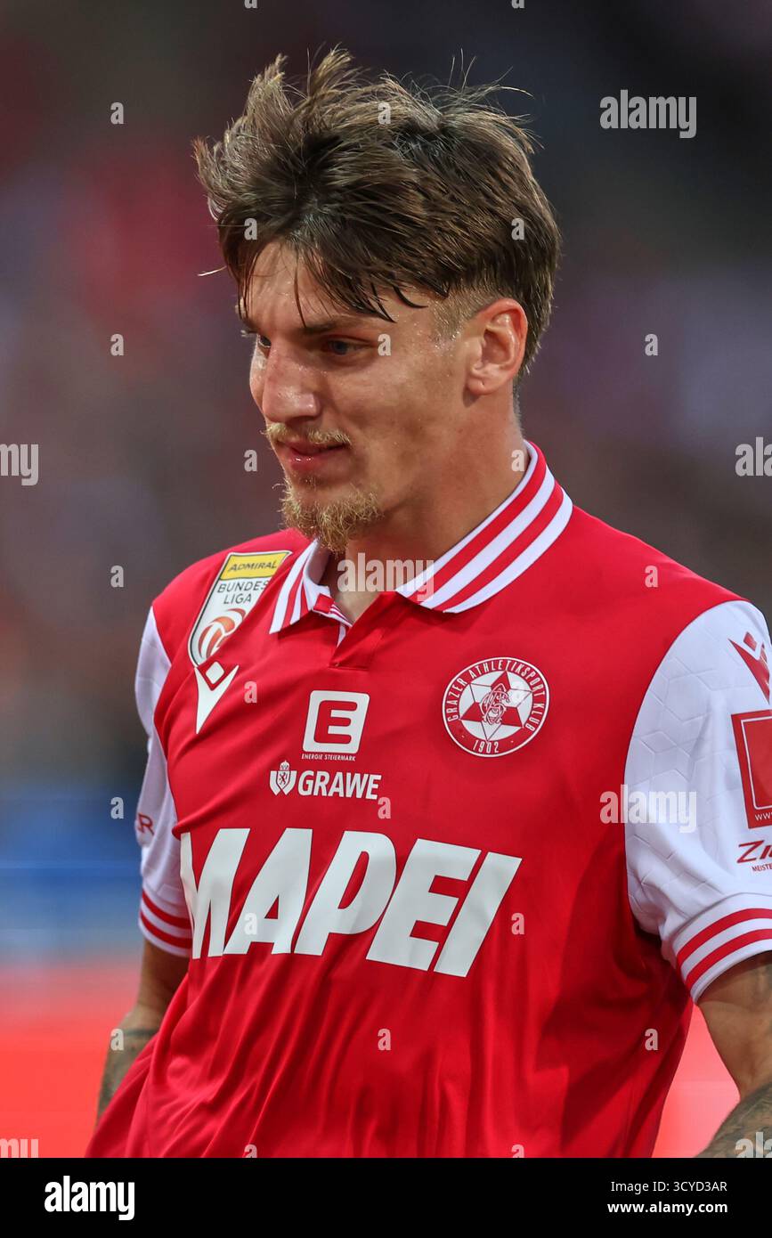 Österreichisches Bundesliga-Spiel zwischen Grazer AK 1902 und TSV Egger Glas Hartberg. Dynamische Fußball-Action, Spieler in Bewegung, Emotionen, Stadionatmosphäre und Teamgeist in professionellen Details. Die Abbildung zeigt Tio Cipot (GAK). Stockfoto