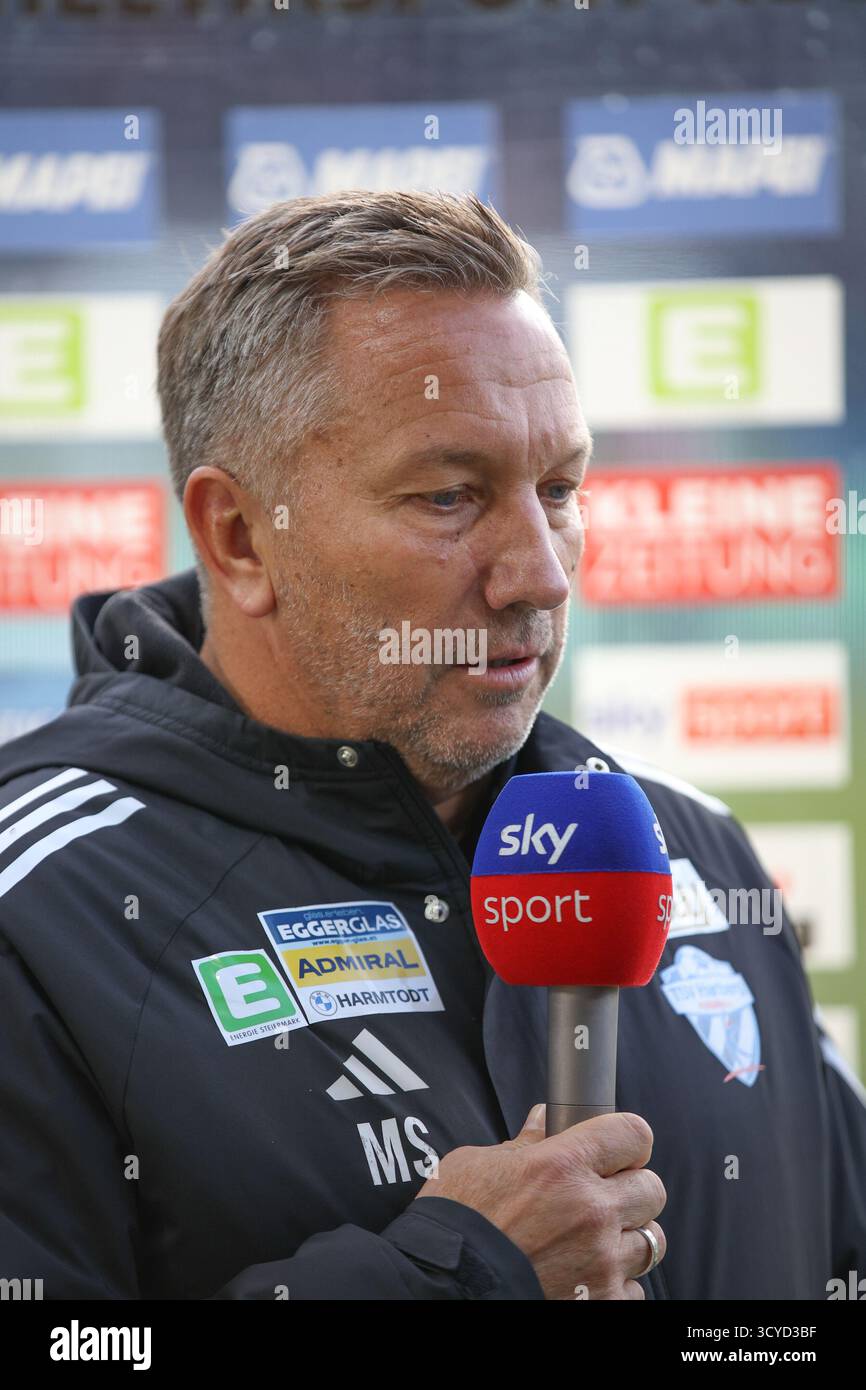 Österreichisches Bundesliga-Spiel zwischen Grazer AK 1902 und TSV Egger Glas Hartberg. Dynamische Fußball-Action, Spieler in Bewegung, Emotionen, Stadionatmosphäre und Teamgeist in professionellen Details. Das Bild zeigt Cheftrainer Manfred Schmid (Hartberg). Stockfoto