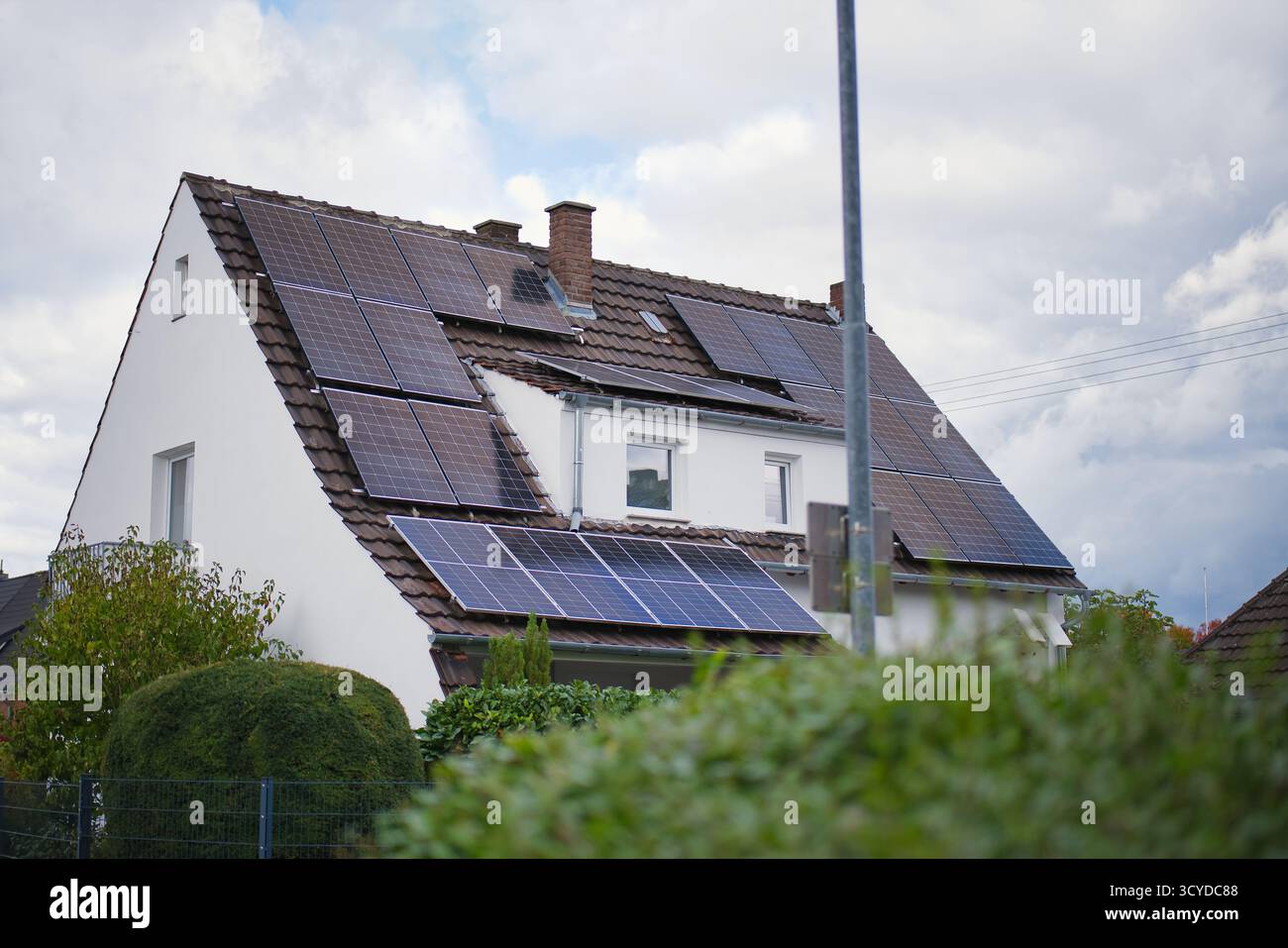 Solarpaneele auf modernem Familiendach, nachhaltiges Wohngebäude mit erneuerbarem Energiesystem, umweltfreundliche Stromerzeugung, Vorstadt Stockfoto