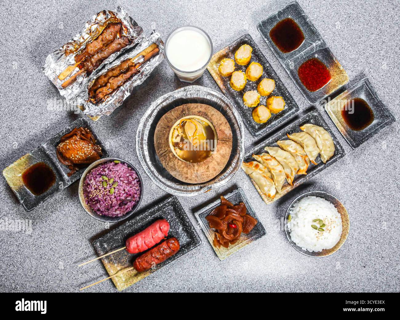 Holzkohle gegrillte Hähnchenspieße, glasierte Hähnchenflügel, gegrillte Wurst, Kokos-Shumai-Knödel, duftender Reis, Kokosnuss Purple Rice, konservierte Radis Stockfoto