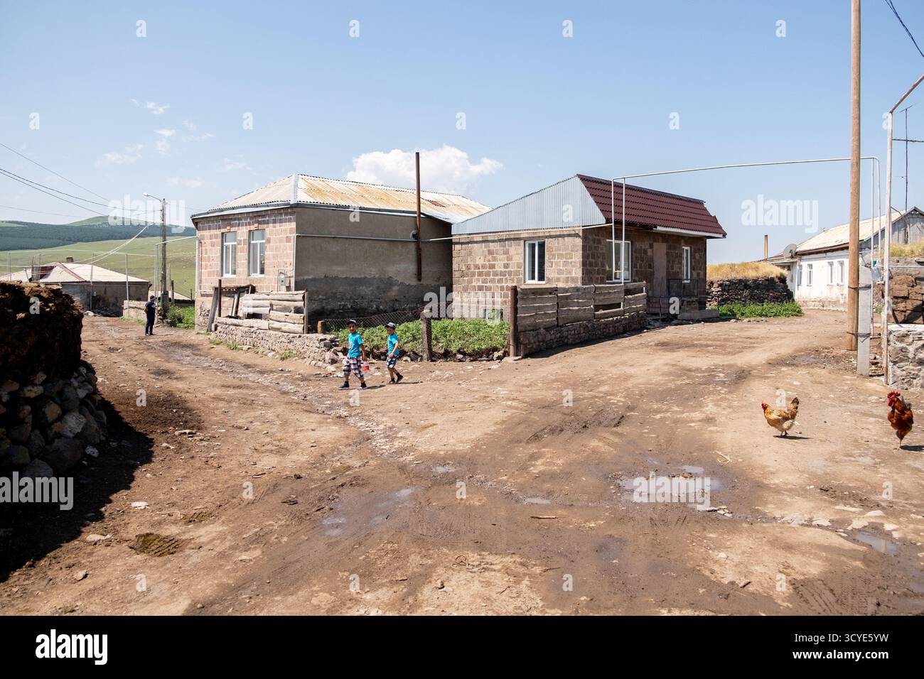Ländliches Dorf mit traditionellen Steinhäusern und großen Stapeln getrockneter Gülle, die als Brennstoff in den Vorhöfen gelagert werden. Javakheti, Georgien. 18. Juli 2020. Stockfoto