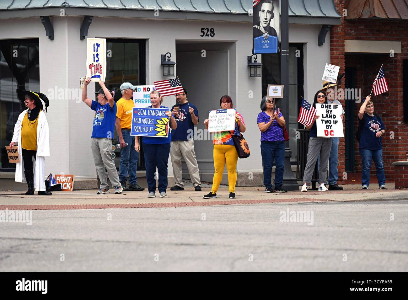 EMPORIA, KANSAS - 18. OKTOBER 2025 Protest gegen die Richtung, in die Präsident Donald J. Trump das County einnimmt, marschieren rund 300 Einwohner und Studenten der Emporia State University um die Hauptverkehrskreuzung in der Innenstadt von Emporia mit Plakaten und Schildern, die Trump verraten. Stockfoto