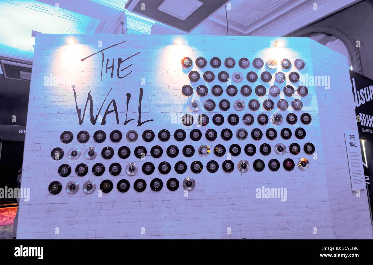 LIVERPOOL, ENGLAND - 18. August 2025: Die Installation „The Wall“ bei The British Music Experience enthält ein Gitter von Schallplatten und CDs, die legendäre Persönlichkeiten zelebrieren Stockfoto
