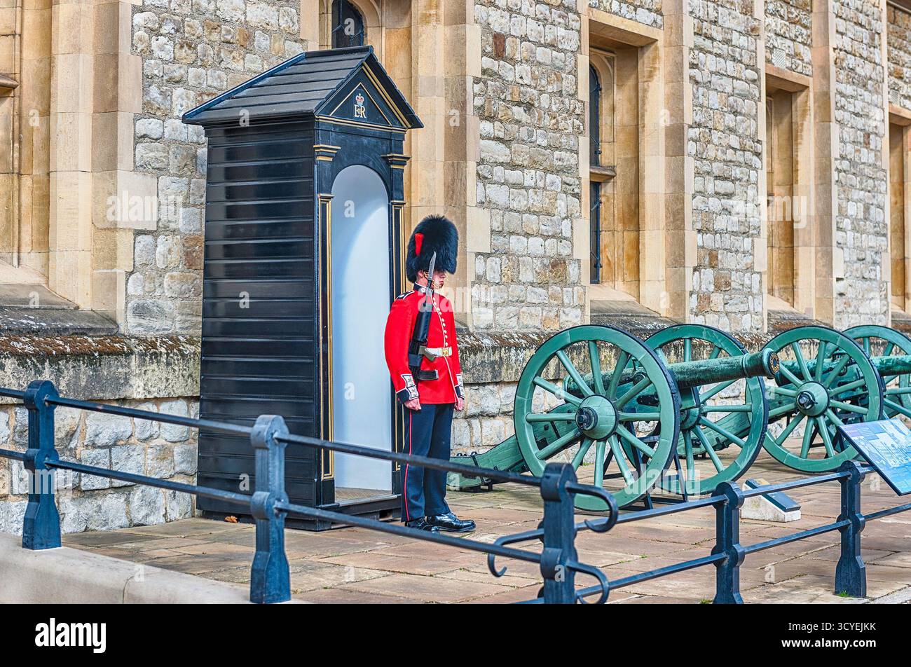 LONDON - 13. APRIL 2022: Typisch englische Garde in rotem Mantel und Bärenfellhut bewacht eine Wachtwache im Tower of London, dem berühmten Royal Palace Stockfoto
