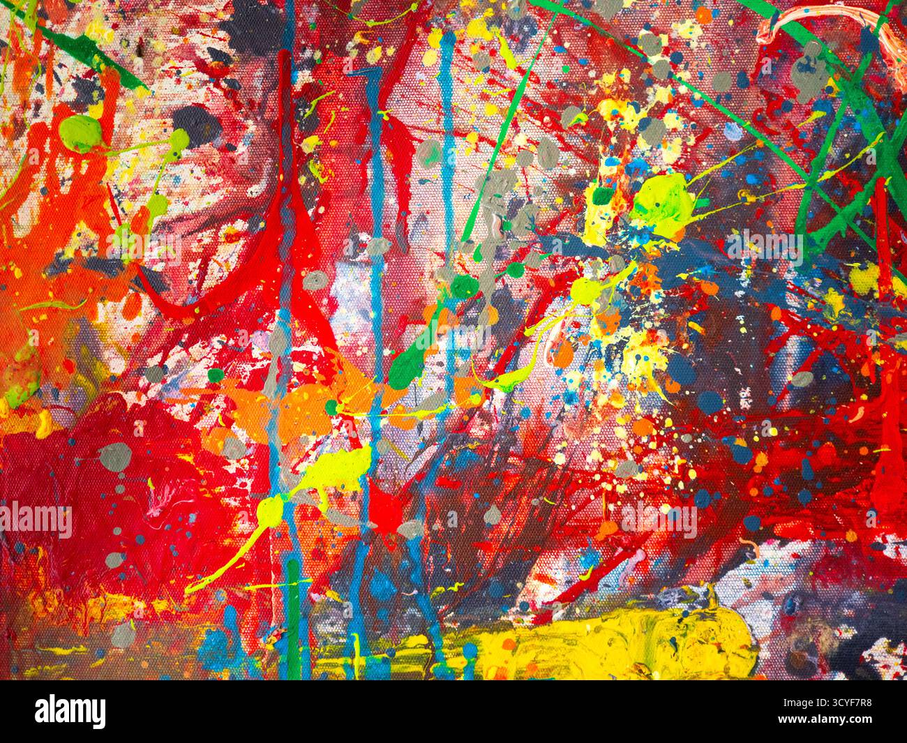 Abstrakt lebendiger Farben, die über die Leinwand gespritzt werden Stockfoto