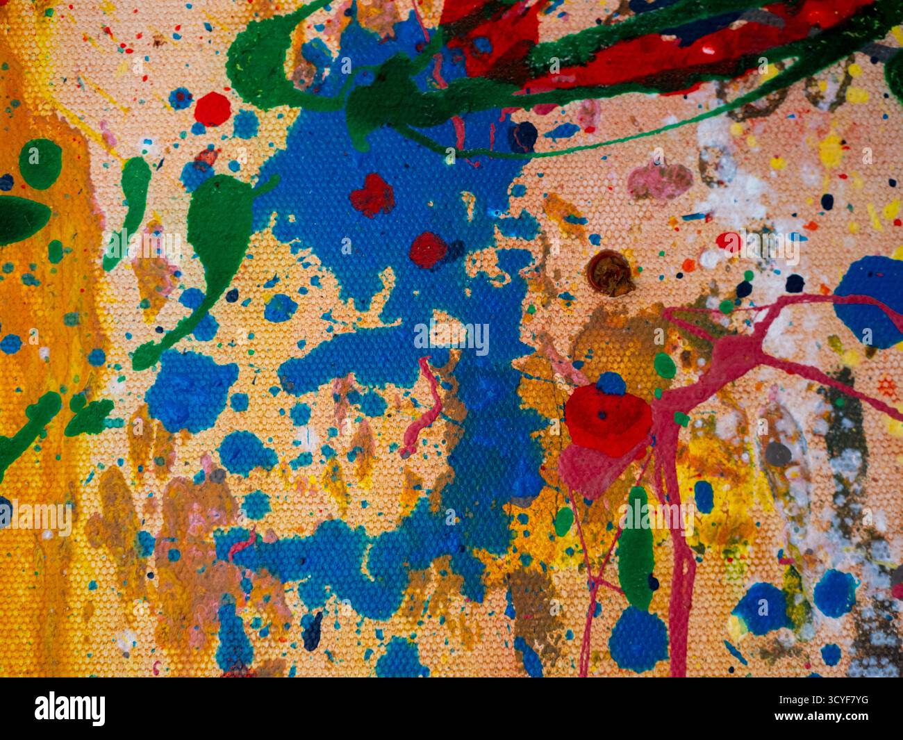 Abstrakt lebendiger Farben, die über die Leinwand gespritzt werden Stockfoto