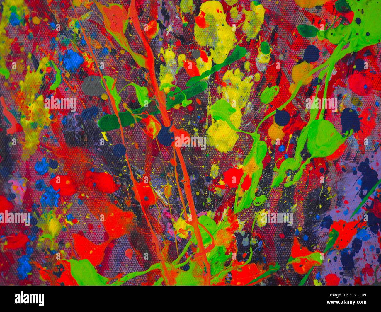Abstrakt lebendiger Farben, die über die Leinwand gespritzt werden Stockfoto