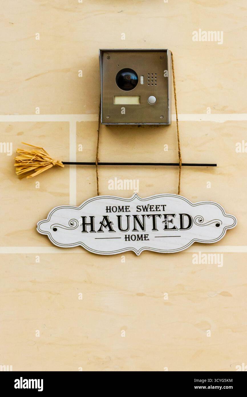 Home Sweet Haunted Home Schild mit Gegensprechanlage und Besen Dekor für Halloween Stockfoto