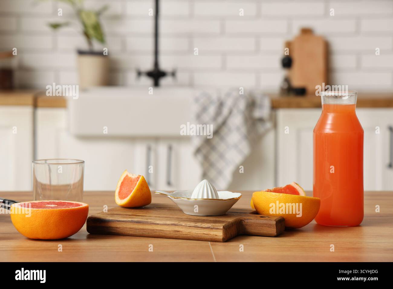KeramikEntsafter und Flasche Grapefruitsaft auf dem Tisch in der Küche Stockfoto