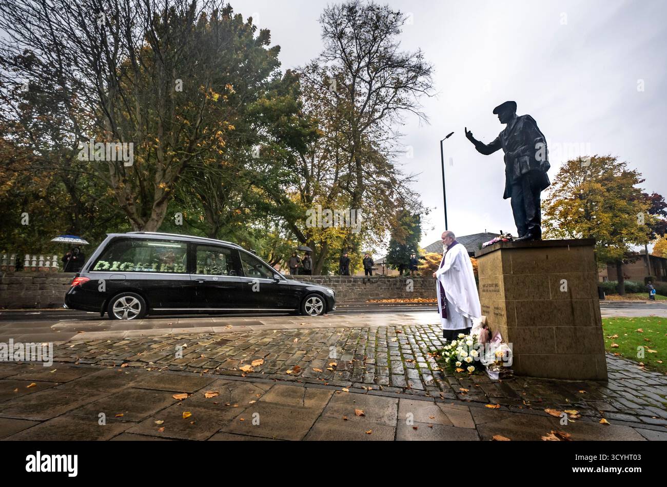 Der Trauerzug für Dickie Bird führt an der lebensgroßen Bronzestatue von Dickie Bird in der Nähe der St. Mary’s Church in Barnsley vorbei. Bilddatum: Sonntag, 19. Oktober 2025. Harold „Dickie“ Bird starb im September im Alter von 92 Jahren. Stockfoto