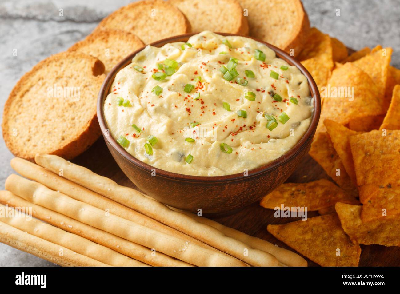 Deviled Egg Dip festliche Buffetspeise mit Pommes Frites, Brotstangen und Keksen in Nahaufnahme auf einem Teller auf dem Tisch. Horizontal Stockfoto