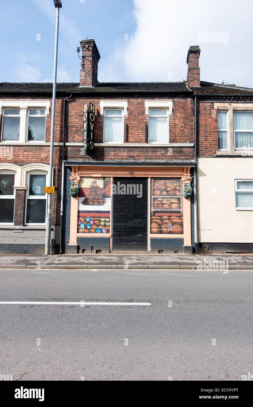 Viktorianische Reihenhäuser mit geschlossenem Geschäft mit farbenfrohen Obst- und Gemüsegrafiken auf Fensterläden Stockfoto
