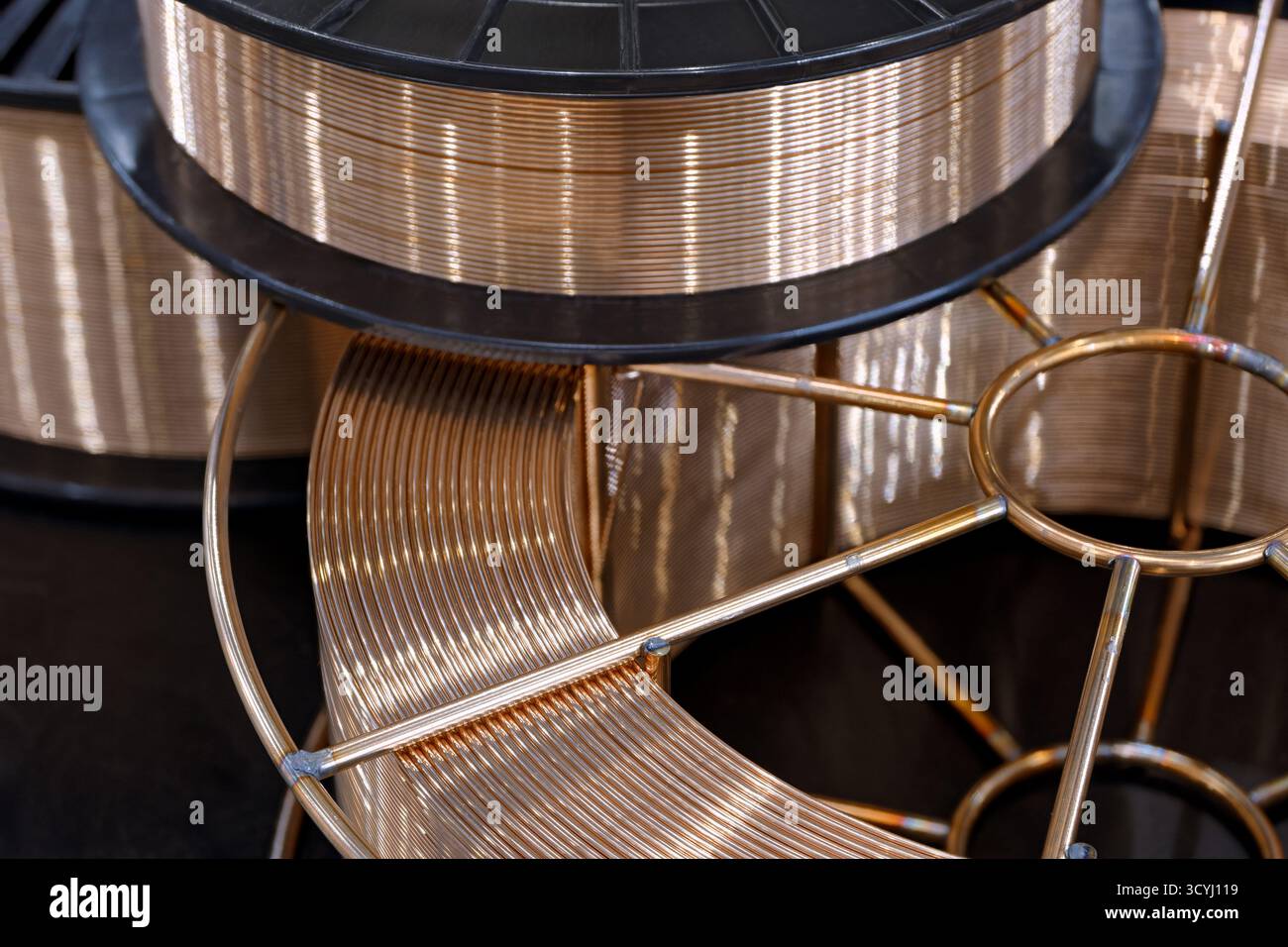 Spule mit kupferbeschichtetem Schweißdraht für halbautomatische Schweißmaschine, Nahaufnahme, abstrakter Hintergrund Stockfoto