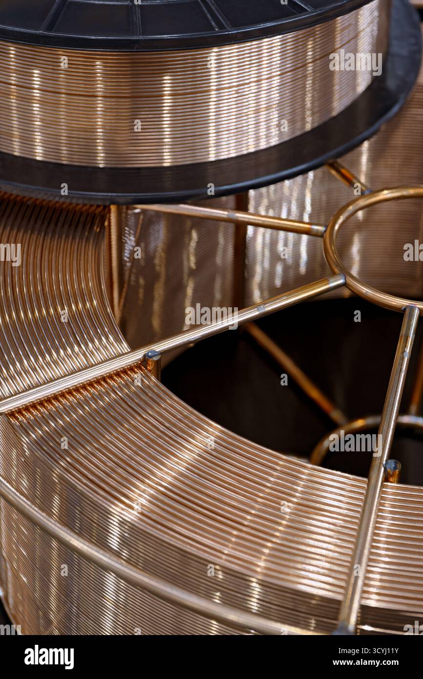 Spule mit kupferbeschichtetem Schweißdraht für halbautomatische Schweißmaschine, Nahaufnahme, abstrakter Hintergrund Stockfoto