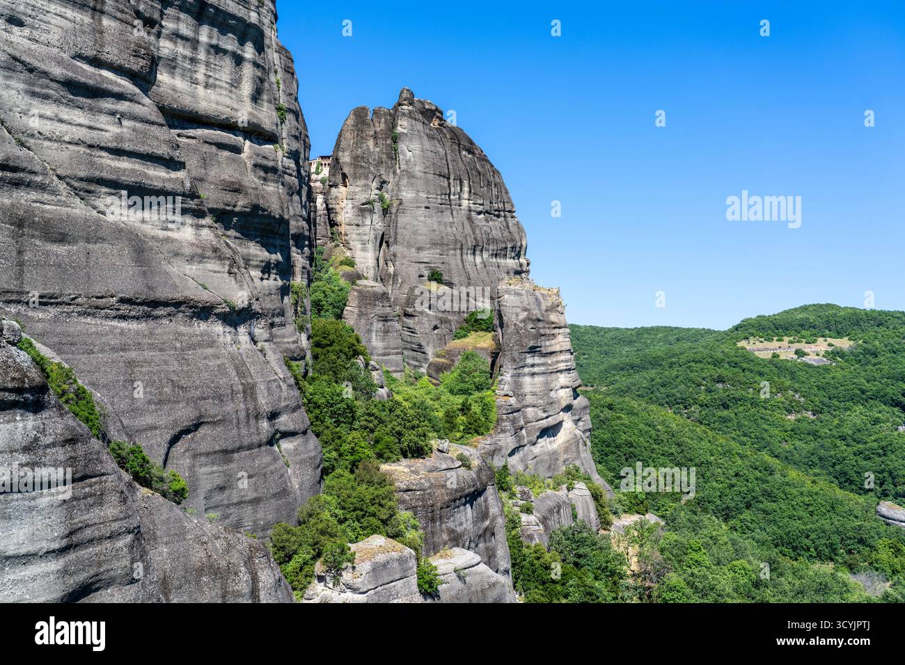 Steile Steinklippen in Meteora Griechenland mit Wald unten Stockfoto
