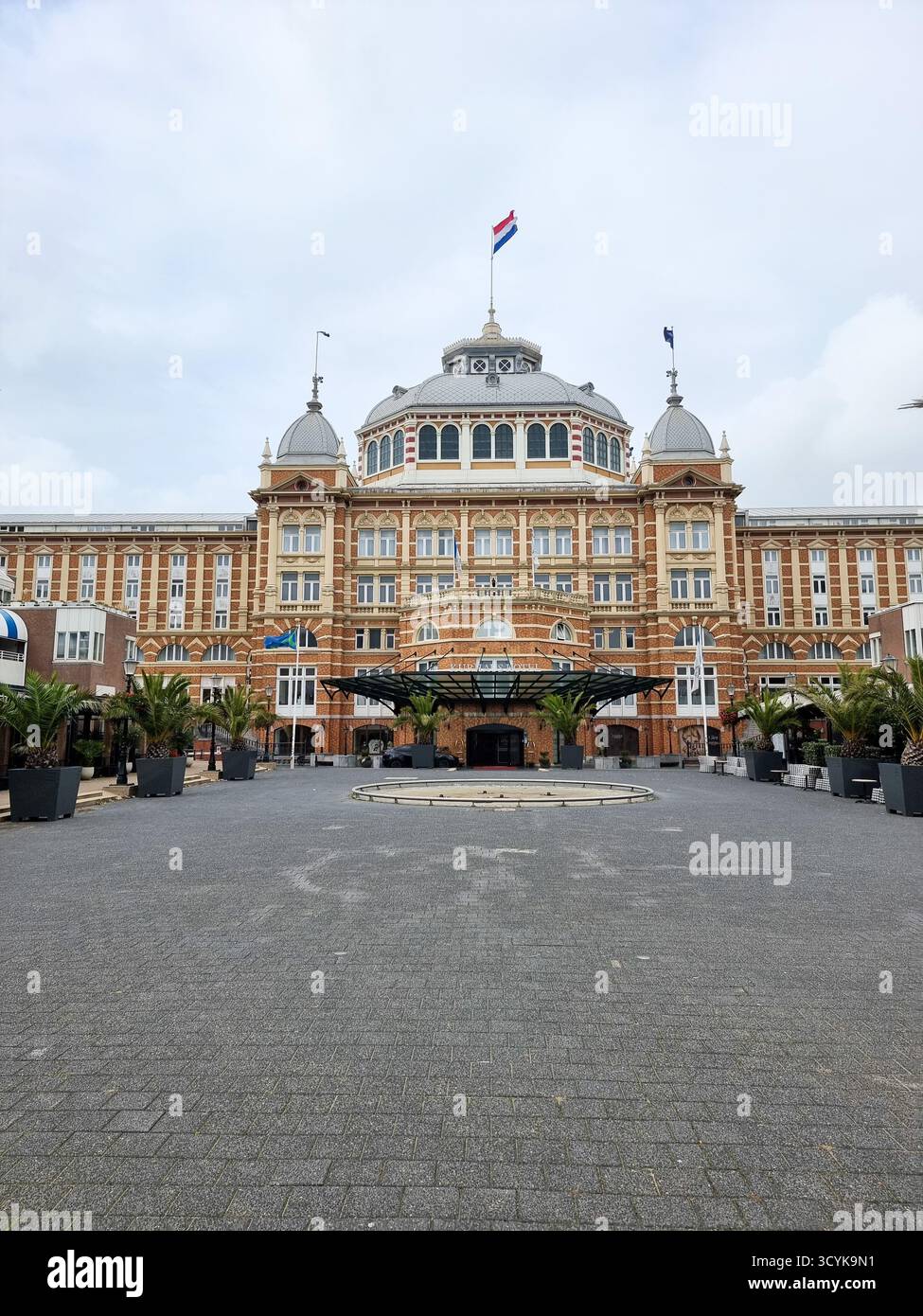Grand Hotel Amrâth Kurhaus Scheveningen in den Haag Niederlande mit niederländischer Flagge auf dem Dach / der Kuppel; monumentales Gebäude - Smartphone-aufgenommenes Stockfoto