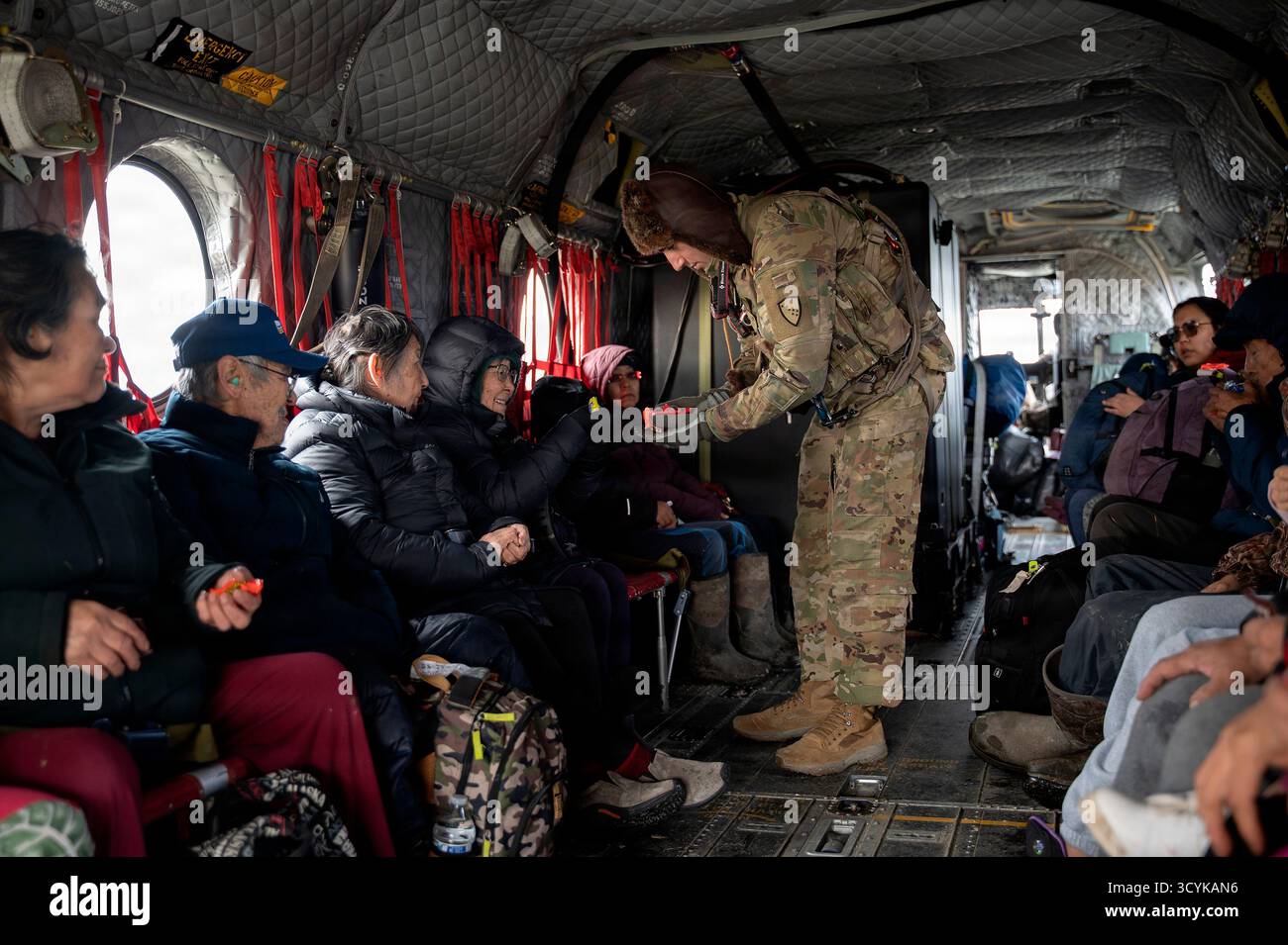 Kwigillingok, Vereinigte Staaten von Amerika. Oktober 2025. Die Nationalgarde der Alaska Army CH-47 Chinook Aircrew verteilt Süßigkeiten an die Bewohner während der Evakuierungsoperationen nach extremen Wetterbedingungen, die durch die Überreste des Taifuns Halong verursacht wurden, am 16. Oktober 2025 in Kwigillingok, Alaska. Der Sturm verdrängte mindestens 1500 Ureinwohner und ließ Dörfer in Trümmern zurück. Gutschrift: SSgt. Joseph Moon/Alaska National Guard Photo/Alamy Live News Stockfoto