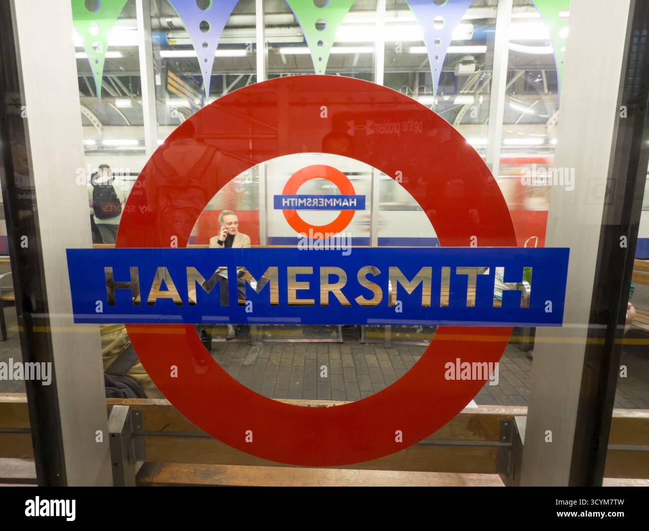 Eine detaillierte Nahaufnahme des berühmten Londoner U-Bahnrundschildes, das die Hammersmith Station markiert und die unverwechselbare Marke der U-Bahn hervorhebt Stockfoto