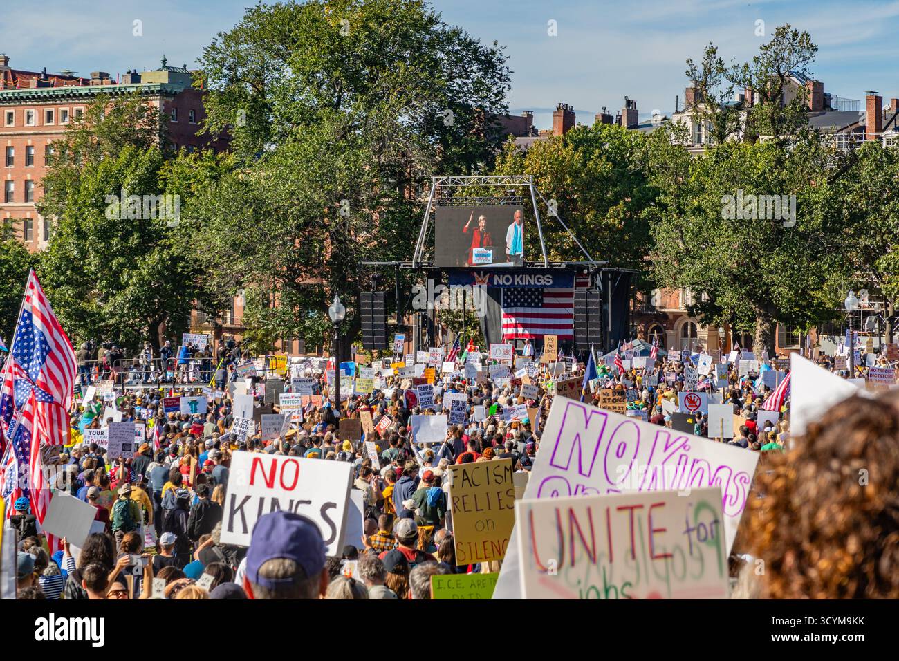 Boston, MA, USA-18. Oktober 2025: Anti-Trump-Demonstranten mit pro-Demokratie-Zeichen beobachten Senatorin Elizabeth Warren eine Rede. Stockfoto